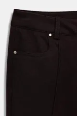 Pantalón flare de tiro bajo color marrón oscuro, con bolsillos delanteros y traseros, pierna entallada y bajo acampanado. Cierre frontal con cremallera y botón.