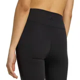 Calza deportiva Adidas de mujer, color negro, de tiro alto y corte semi oxford con botamanga acampanada.