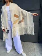 Pashmina color crema tejida en lana merino con apliques de cuero en tonos marrones y flecos en los bordes.