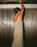 Vestido largo tejido en color dorado con brillo, de breteles finos y escote redondo.