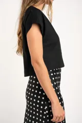 Camisa negra corta de lino y viscosa, con calce oversize, escote en V y cierre frontal con botones.