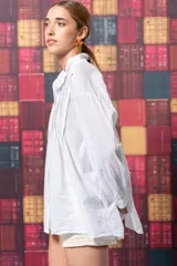 Camisa blanca de algodón con corte amplio, tablitas en la parte delantera y volados en el cuello.