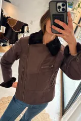 Campera de cuero genuino color marrón, estilo biker, con cuello y puños de piel sintética negra, bolsillos con cierre y cierre frontal diagonal.