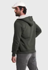 Canguro verde militar con capucha forrada en piel sintética color crema, cierre frontal con cremallera, bolsillos tipo canguro y puños y cintura acanalados.