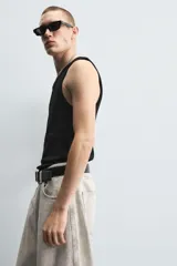 Musculosa negra ajustada de algodón con elasticidad, cuello redondo y sisa ancha.