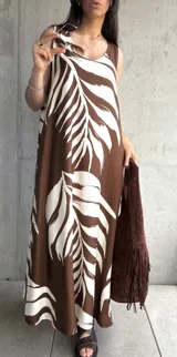 Vestido largo marrón con estampado de hojas blancas, sin mangas y corte holgado.