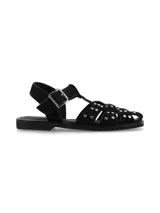 Sandalia estilo cangrejera color negro, confeccionada en cuero gamuza, con tiras entrelazadas decoradas con tachas metálicas plateadas. Cuenta con tira ajustable en el talón con hebilla y suela plana de caucho.