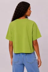 Remera manga corta de algodón color blanco, con cuello redondo y diseño holgado. Cuenta con estampado en el pecho de un paisaje de playa con palmeras en color verde.