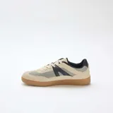 Zapatillas urbanas de malla y ante sintético en tonos beige y negro, con suela de goma marrón y cordones claros.