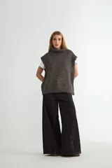 Chaleco de punto gris con cuello alto, diseño sin mangas y corte holgado.