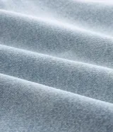 Bermuda de jean corte loose, color azul claro con lavado desgastado, cuenta con bolsillos laterales y traseros, cierre frontal con botón y bragueta, y pasacintos.