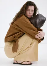 Pantalón recto de tiro medio color beige, confeccionado en mezcla de lino y viscosa. Cuenta con detalle de pinzas, bolsillos laterales y cierre frontal oculto con cremallera, botón y ganchos con tapeta.