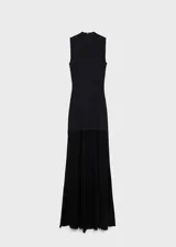 Vestido negro de punto ajustado al cuerpo, sin mangas y con cuello alto. Largo hasta la rodilla y ruedo con flecos.