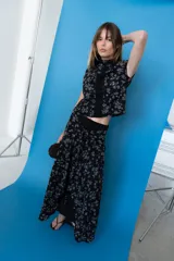 Falda midi cruzada color negro con estampado floral en tono gris, con sistema de atado en la cintura.