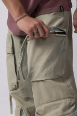 Jean baggy de corte holgado con múltiples bolsillos cargo frontales con cierre metálico. Presenta un acabado lavado, tiro medio y tiras de ajuste en la botamanga.