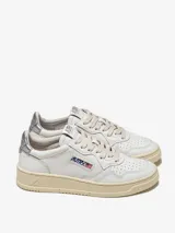 Zapatillas urbanas Autry Medalist Low para mujer, de cuero blanco con detalles en plateado en el talón y logo de la marca en el lateral.