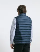 Chaleco acolchado de diseño capitoneado con cierre frontal al tono, cuello alto y ribetes en sisas y ruedo.