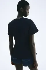 Top de manga corta color azul marino, con cuello redondo y corte entallado que se abre ligeramente hacia abajo, con pinzas moldeadoras en la cintura.