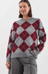 Sweater de punto con diseño de rombos estilo argyle en tonos gris y bordó. Presenta cuello redondo y terminaciones acanaladas en puños y cintura.