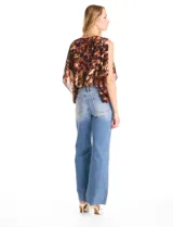 Blusa de gasa con estampado abstracto en tonos marrones y negros. Presenta cuello a la base, diseño de mangas tipo capa con aberturas laterales y silueta holgada con ruedo en punto smock.