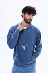 Buzo canguro oversize de felpa color azul, con capucha y estampa gráfica en la espalda que incluye la frase 'Lucky You' y un encendedor con el número 777.