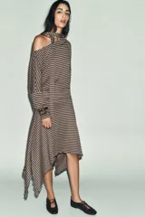 Falda midi de tiro medio, con cintura acabada en vuelta y bajo asimétrico. Diseño de rayas horizontales en tonos beige y marrón.