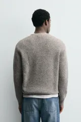 Jersey de punto perlado con ajuste relajado, cuello redondo y manga larga, con acabados en rib en puños y cintura.