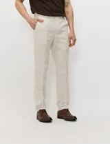 Pantalon de lino color beige, de corte recto con bolsillos delanteros y traseros con cierre de botón.