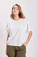 Remera blanca de algodón con cuello redondo y mangas cortas. Presenta un estampado de estrella en el frente.