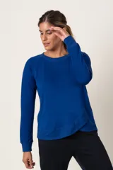 Buzo deportivo celeste de algodón, con cuello redondo y terminación en volado cruzado en el ruedo.