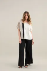 Blusa de lino de diseño contemporáneo, con escote cuadrado y mangas cortas en recortes que combinan distintas texturas. Su propuesta incorpora una franja vertical en contraste que aporta dinamismo y personalidad, mientras que el calce relajado la convierte en una prenda fresca y versátil.