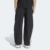 Pantalón Adidas de la línea Z.N.E. en color negro, con corte holgado y diseño de pierna ancha. Confeccionado en tejido ripstop ligero y resistente, cuenta con cintura elástica con cordón de ajuste y logo de las 3 Barras estampado en goma mate.