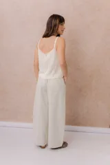 Pantalón de denim liviano color beige, de calce amplio y relajado con pierna recta. Cuenta con cintura elastizada, cordón regulable, bolsillos laterales y costuras delanteras verticales que estilizan la silueta.