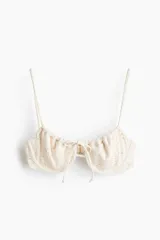 Top de bikini balconette con aros y textura perforada, tirantes finos ajustables y lazada frontal.