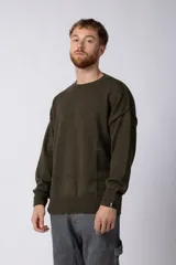 Sweater de punto grueso en color verde oliva, con diseño oversized, cuello redondo y mangas largas con puños acanalados.