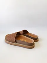 Sandalias chatas color camel, con diseño capitoneado en la tira superior. Fabricadas en cuero.