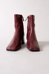 Bota de caña media con textura de reptil en color negro, punta cuadrada y taco bloque.