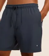Bermuda de baño color beige, con cintura elástica y cordón de ajuste negro. Presenta un pequeño parche gomoso en el ruedo y bolsillos laterales.