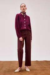 Pantalón de cuero color burdeos, de tiro medio, corte recto y largo hasta el tobillo.