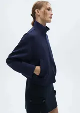 Chaqueta tipo bomber de corte crop y diseño oversize, color azul marino. Presenta cuello alto, cierre frontal con cremallera y dos bolsillos laterales.