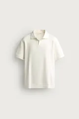 Polo regular fit color blanco, de manga corta con cuello solapa, abertura frontal y acabado en rib con textura de rayas verticales.