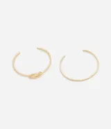 Kit de dos brazaletes rígidos dorados, uno liso y otro con un nudo decorativo.