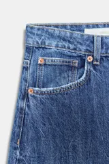 Jeans de mujer color beige claro, tiro medio, estilo balloon baggy con pierna ancha y largo completo. Presenta costuras visibles y un lavado que le da un aspecto desgastado.