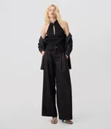 Pantalón de sastrería negro de modelado amplio, con pinzas frontales y cintura con pasadores.