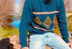 Sweater de lana color azul con cuello redondo y diseño intarsia de rombos color ocre y rayas horizontales color naranja.