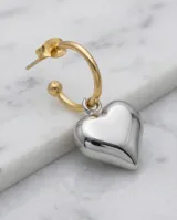 Aros colgantes con diseño de corazón plateado y argolla dorada.