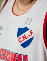 Musculosa de básquet blanca con detalles en azul y rojo, con el escudo del Club Nacional de Football y el logo de Umbro.