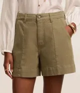 Short de mujer de sarga color beige claro, tiro alto, con pespunte contrastante en color blanco o crema. Presenta un corte regular y bolsillos delanteros y traseros.