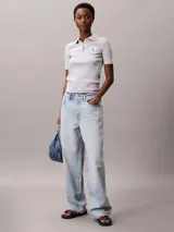 Chomba de Calvin Klein Jeans confeccionada en tejido de algodón con elastano, de corte regular y textura acanalada. Presenta cuello tipo polo con cartera de dos botones y una insignia distintiva de la marca aplicada en el pecho.