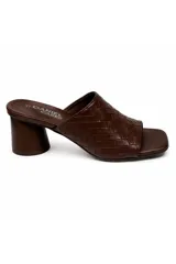 Zueco Daniel Casen de símil cuero marrón, con capellada ancha de diseño trenzado, punta cuadrada y taco cilíndrico.
